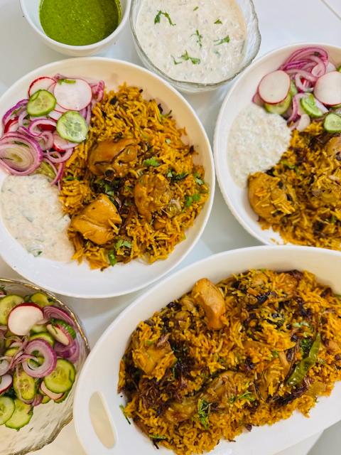 Hand-layered chicken biryani in a brass serving dish